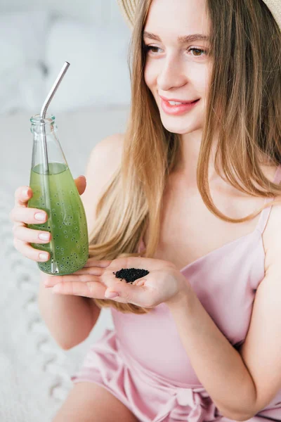 Dziewczyna pije zdrowy zielony napój z nasion bazylii — Zdjęcie stockowe