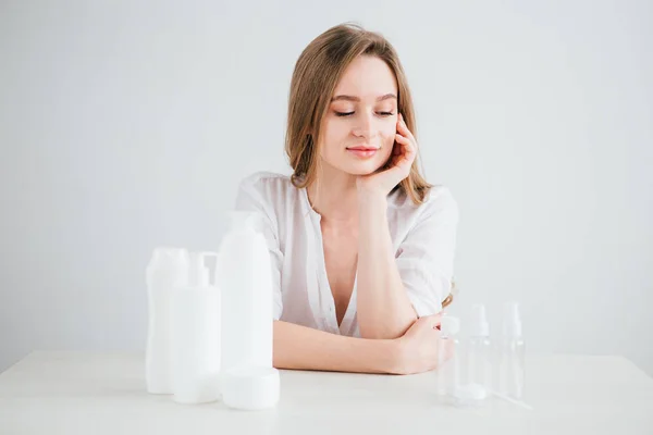 Girl compares the size of cosmetic bottles for travel to save space in the suitcase