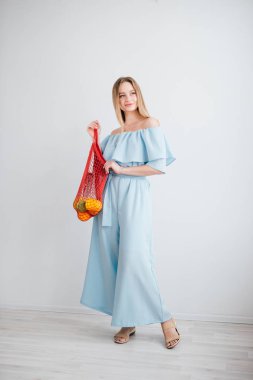 Bir dize çanta taze meyve ile genç güzel kız