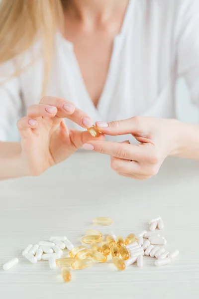 Joven hermosa chica elige pastillas, coloridas cápsulas de tabletas, vitaminas, suplementos dietéticos — Foto de Stock