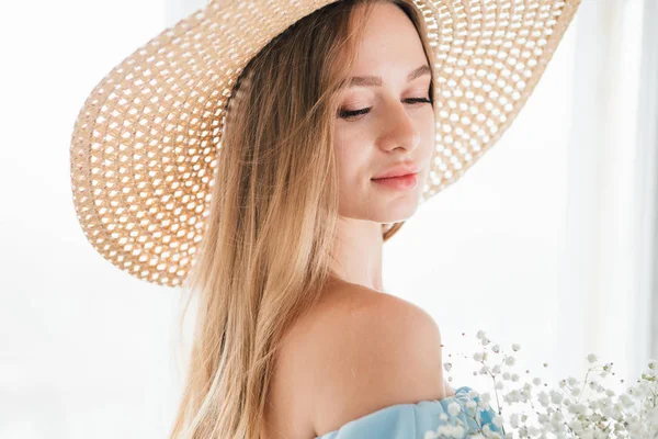 Chica con el pelo largo y sombrero posando con un ramo de flores blancas — Foto de Stock