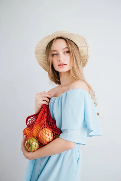 Joven hermosa chica con fruta fresca en una bolsa de hilo — Foto de Stock