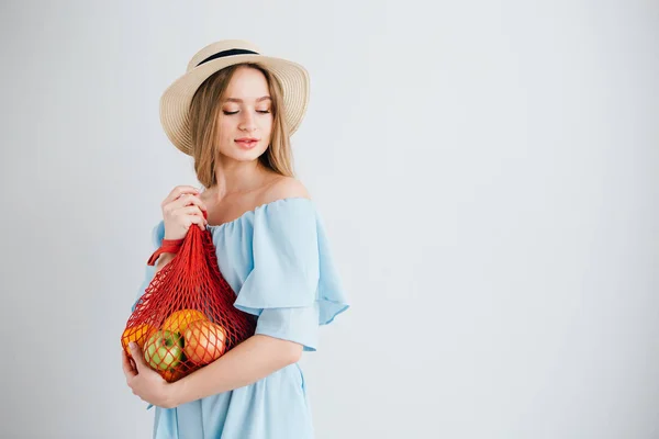 Joven hermosa chica con fruta fresca en una bolsa de hilo — Foto de Stock