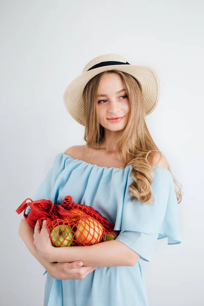 Joven hermosa chica con fruta fresca en una bolsa de hilo — Foto de Stock