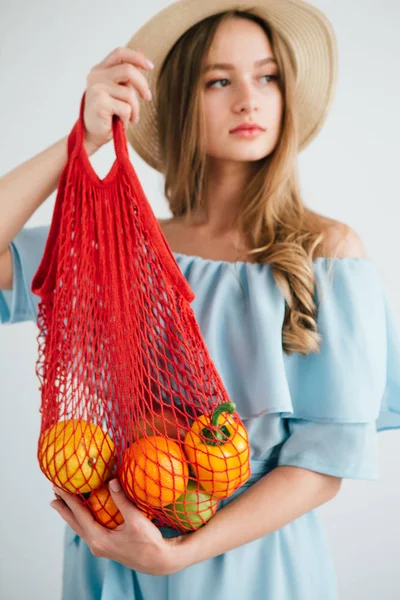 Joven hermosa chica con fruta fresca en una bolsa de hilo — Foto de Stock