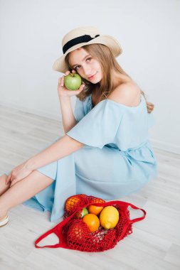 Bir dize çanta taze meyve ile genç güzel kız