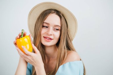 Taze sarı biber tutan genç güzel kız
