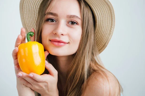 Young beautiful girl holding fresh yellow pepper — Stock Photo, Image