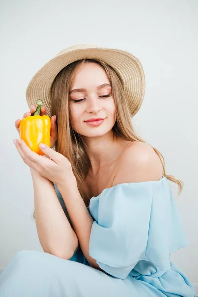 Young beautiful girl holding fresh yellow pepper — Stock Photo, Image