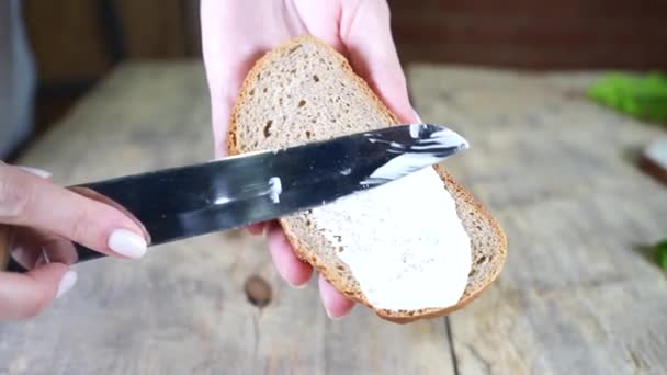Una mano sosteniendo un pedazo de pan en una tabla de cortar — Vídeos de Stock