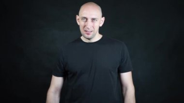 Siyah tişörtlü kel bir Avrupalı..