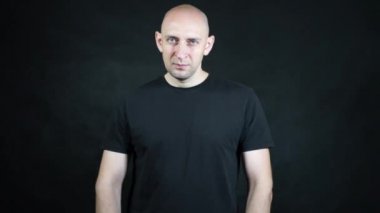 Siyah tişörtlü kel bir Avrupalı..