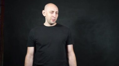 Siyah tişörtlü kel bir Avrupalı..