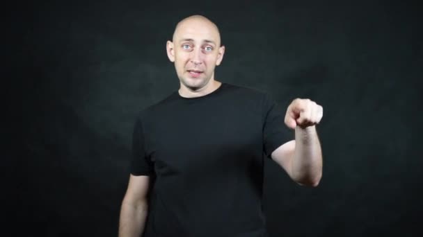 En skallig europeisk man i svart t-shirt. — Stockvideo