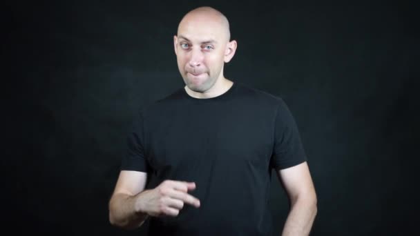 En skallig europeisk man i svart t-shirt. — Stockvideo