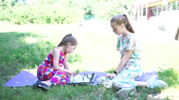 Маленька дівчинка сидить на траві — стокове відео