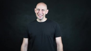 Siyah tişörtlü kel bir Avrupalı..