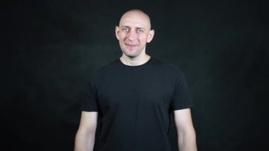 Siyah tişörtlü kel bir Avrupalı..