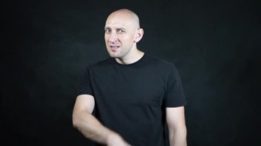 Siyah tişörtlü kel bir Avrupalı..