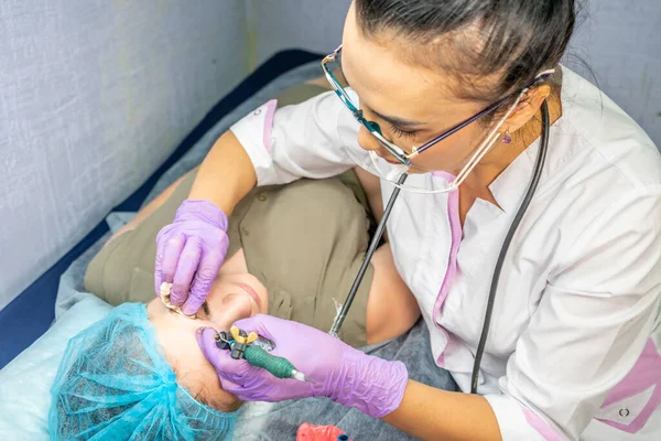 Güzel bir kadın kozmetoloji salonunda kalıcı makyaj yapıyor..