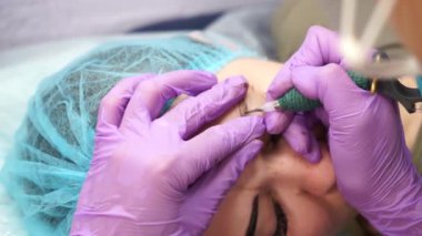 Güzel bir kadın kozmetoloji salonunda kalıcı makyaj yapıyor..