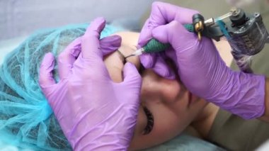 Güzel bir kadın kozmetoloji salonunda kalıcı makyaj yapıyor..