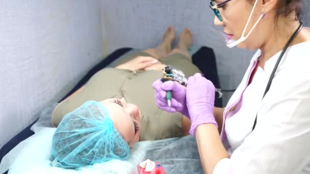 Bella donna che fa trucco permanente nel salone di cosmetologia. — Video Stock