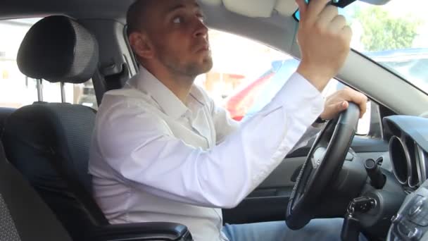 Un hombre sentado en un coche — Vídeo de stock