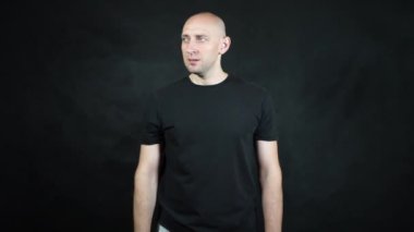 Siyah tişörtlü kel bir Avrupalı..