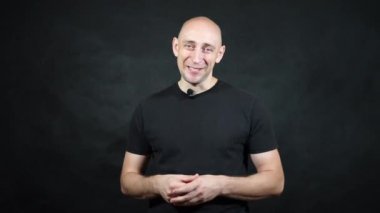 Siyah tişörtlü kel bir Avrupalı..