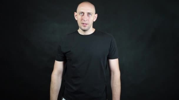 Un uomo europeo calvo con una maglietta nera. — Video Stock
