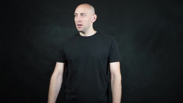 Ein glatzköpfiger Europäer im schwarzen T-Shirt. — Stockvideo
