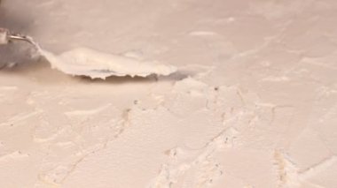  Sanatsal beyaz desenli alçıyı küçük metal palet bıçağıyla sürüyorum.