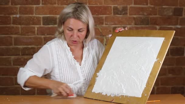 작은 금속 팔레트 나이프를 사용하여 예술적 인 흰색의 회반죽을 칠하는 모습 — 비디오