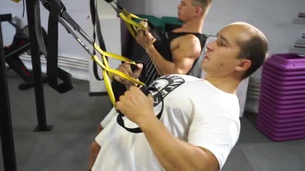 Два кавказьких чоловіки в спортзалі виконують силові вправи — стокове відео