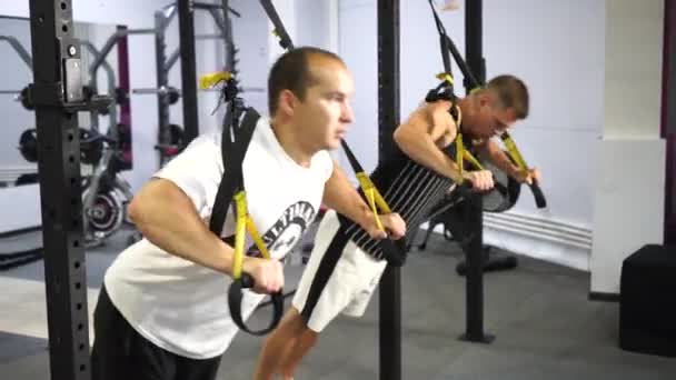 Dois homens caucasianos no ginásio fazendo exercícios de força — Vídeo de Stock