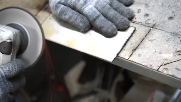 Het strippen van bramen op een metalen deel in een handleiding met een steenkoolzaagmachine — Stockvideo