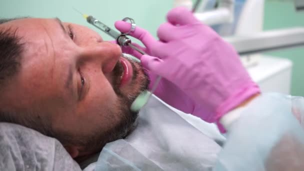 Ο οδοντίατρος θεραπεύει έναν ασθενή. Υψηλής ποιότητας υλικό FullHD — Αρχείο Βίντεο