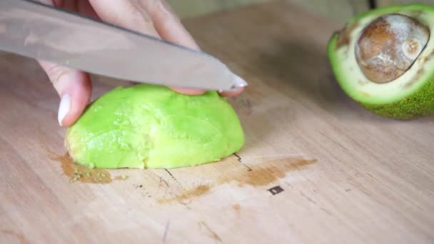 Tagliare un avocado maturo con un coltello di metallo con un manico di legno — Video Stock