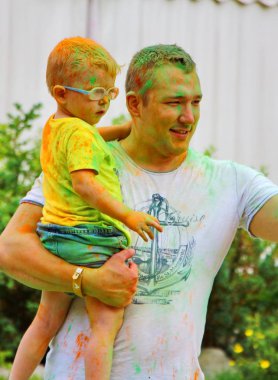 Moskova, Rusya - 14 Temmuz 2018: Renkli Holi renkli Festivali'nde atma. Mutlu baba ve oğul renk Holi Festivali sırasında. Hindistan'ın geleneksel tatil bayram olduğunu.