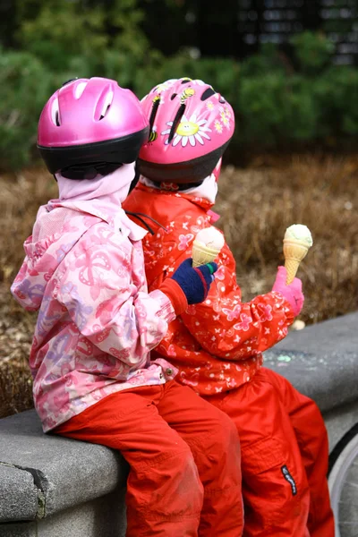 Cyklisté děti jíst zmrzlinu v parku — Stock fotografie