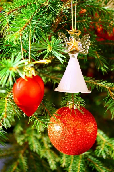 Rode bol, rood hart en glas engel op kerstboom — Stockfoto