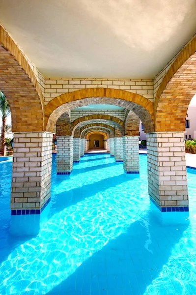 Панорамный бассейн под мостом в курорте — стоковое фото