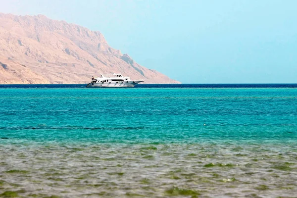 Vita skeppet i blå havet på berget bakgrund i Röda havet — Stockfoto