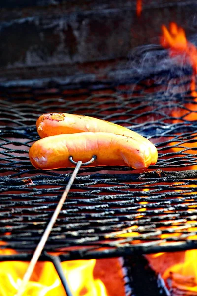 Барбекю. Крупный план жареных колбас на вешалке — стоковое фото