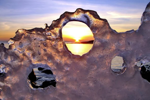 Вид зимнего заката через отверстия во льду — стоковое фото