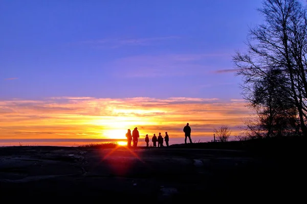 Temné siluety lidí na zimní slunce pozadí — Stock fotografie