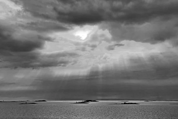 Solen bakom molnen med strålar av ljus som skiner ner på havet — Stockfoto