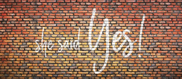 Brick wall with words she said yes. Concept background