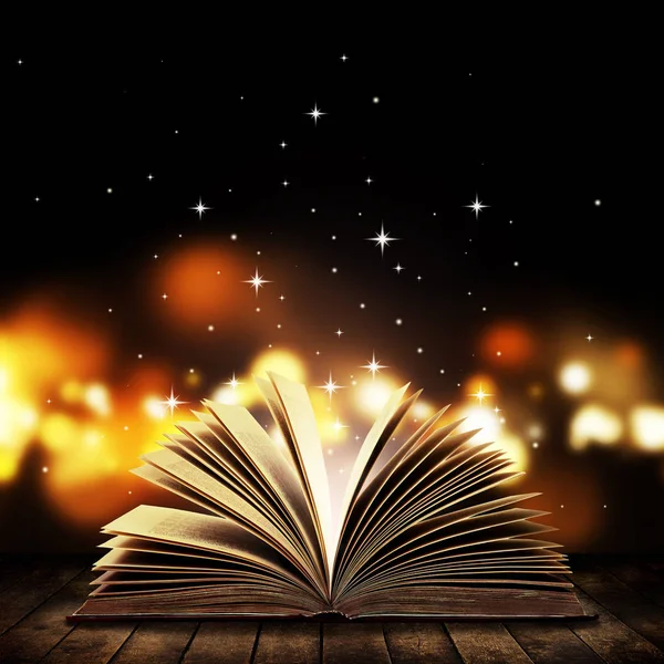 打开书的木制老式表与神秘的魔力明亮的灯光背景 — 图库照片